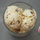 Peanut butter ice cream in glass dish on gray surface